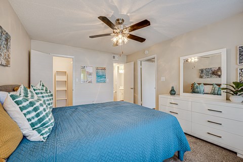 a bedroom with a bed and a ceiling fan at Indian Creek Apartments, Carrollton, 75007